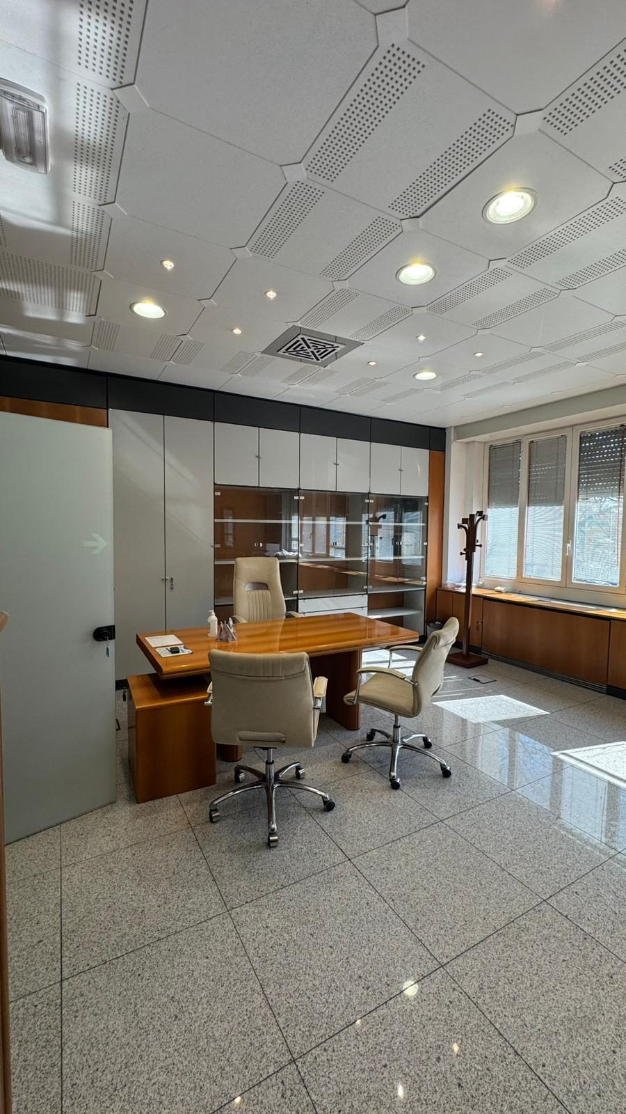 Studio professionale con scrivania, libreria e poltrone, ambiente sobrio adatto al colloquio clinico